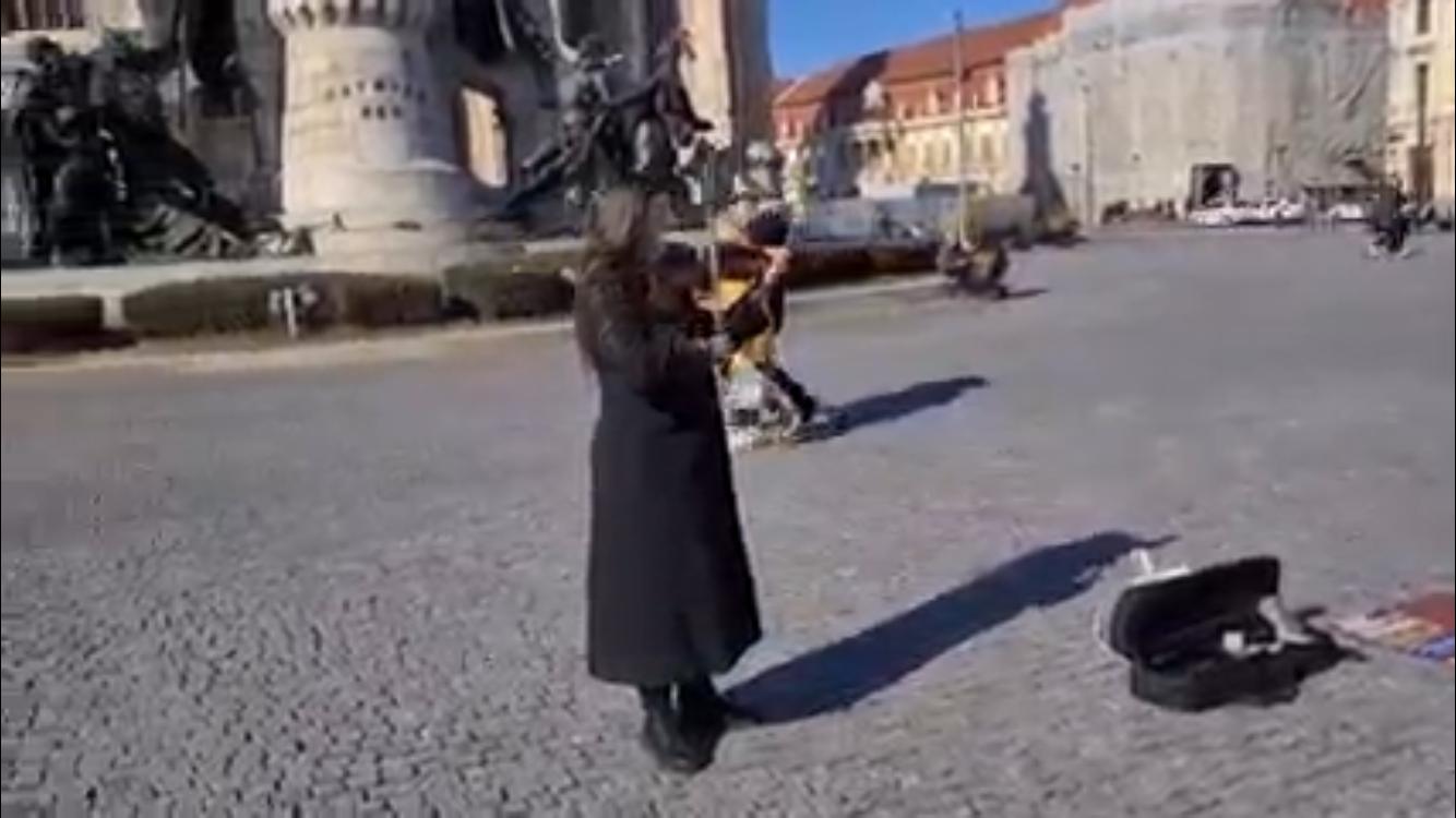 O tânără refugiată din Ucraina cântă la vioară în Piața Unirii. Clujenii