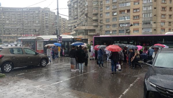 Oameni cu umbrele în stația Mareșal C-tin Prezan din Cluj-Napoca/ Foto: monitorulcj.ro