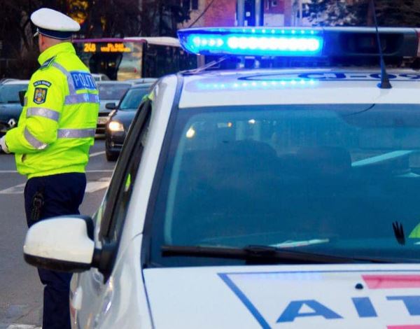 Polițist și mașină de poliție cu girofarul pornit / Foto: arhivă IPJ Cluj