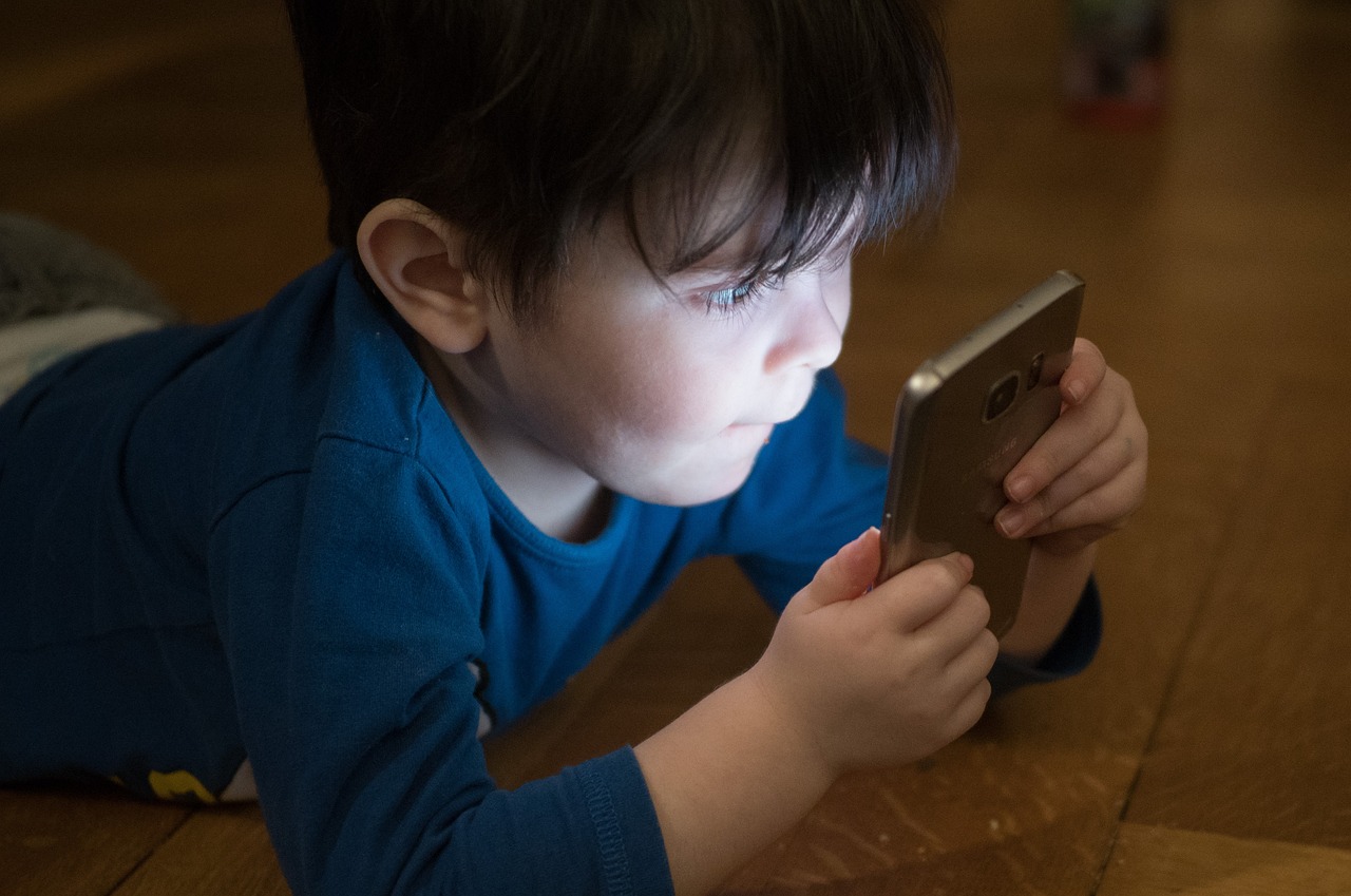 Baiat cu ochii într-un telefon mobil. Foto: Pixabay