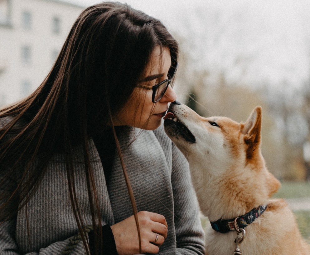 Femeie care pupă un câine pe bot. Foto: Pexels
