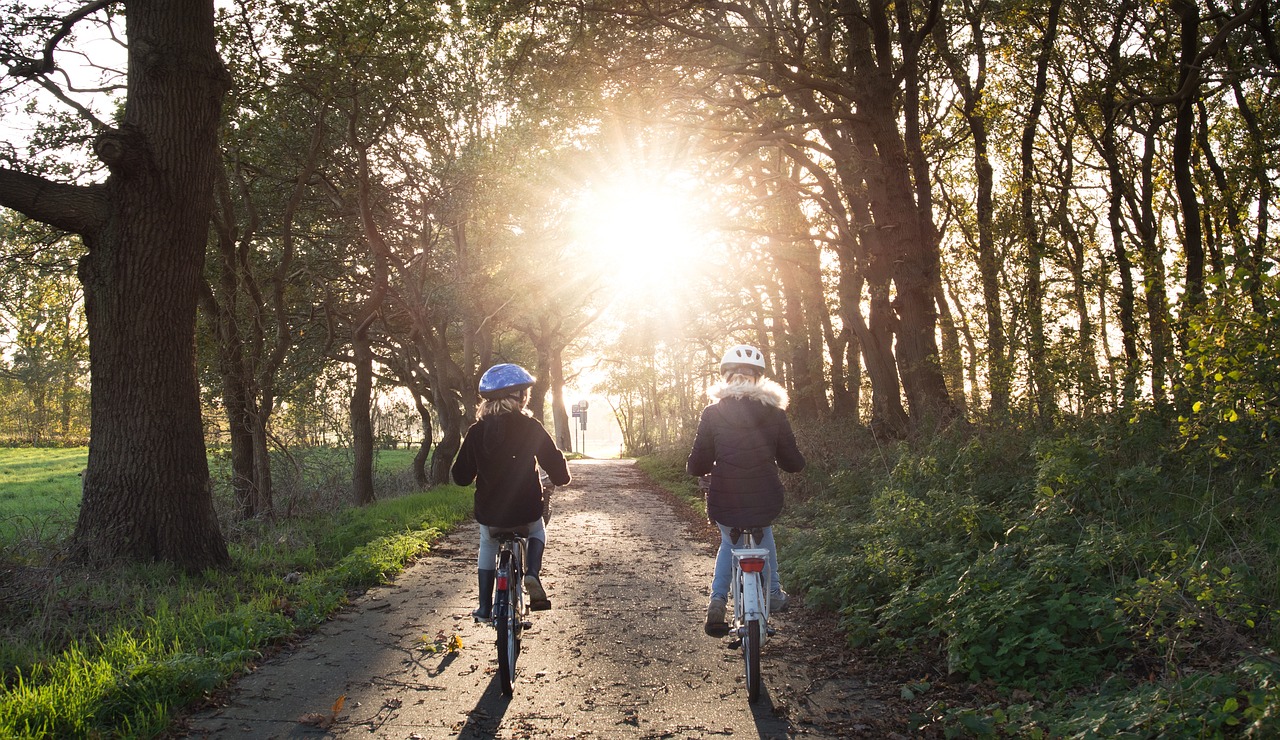 Copii pe bicicletă purtând cască de protecție. Foto: Pixabay