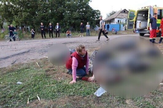 Femeie în genunchi lângă cadavre/ Foto: Zelenskiy / Official - Telegram