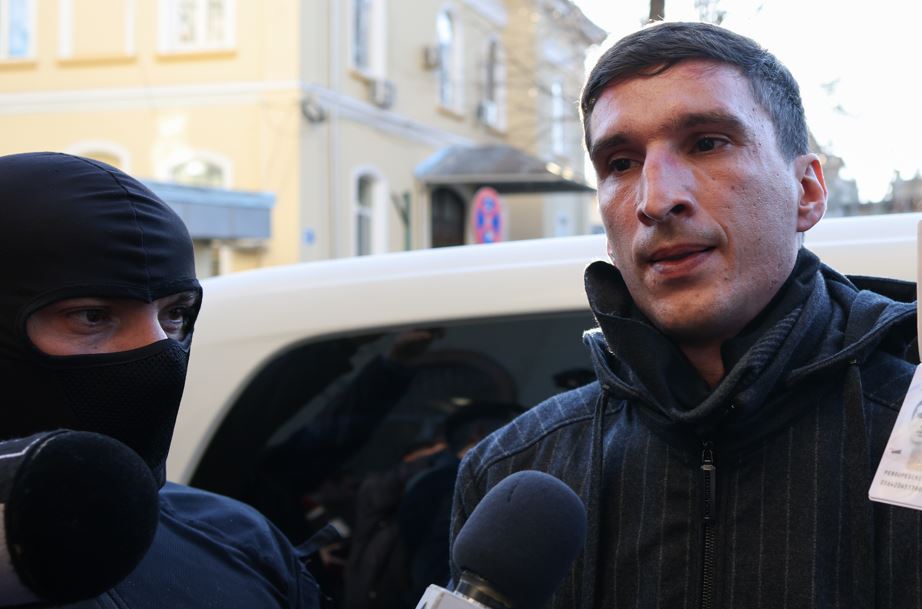 în imagine: Bogdan Peșchir este escortat de către polițiști în sediul IGPR din București