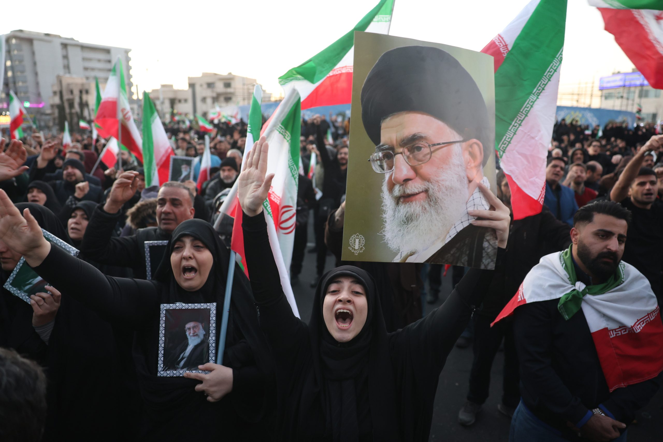 |în imagine: Persoane îndoliate țin în mână fotografii cu liderul suprem iranian