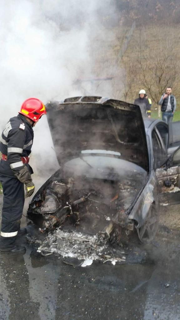 O mașină a luat foc în curtea unei case